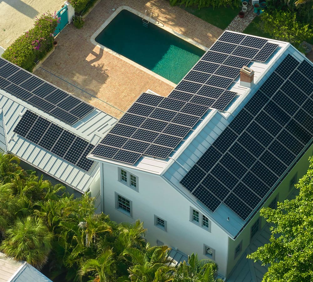 Vista dall'alto di una villa con piscina e pannelli fotovoltaici.